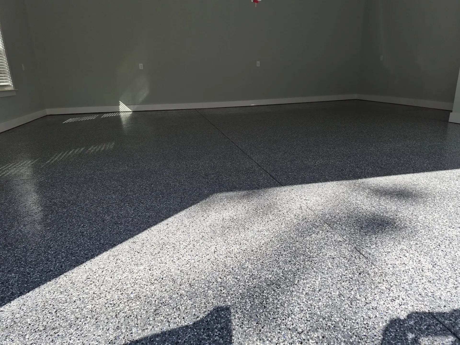 Charcoal and white epoxy flake floor with a glossy sealed finish