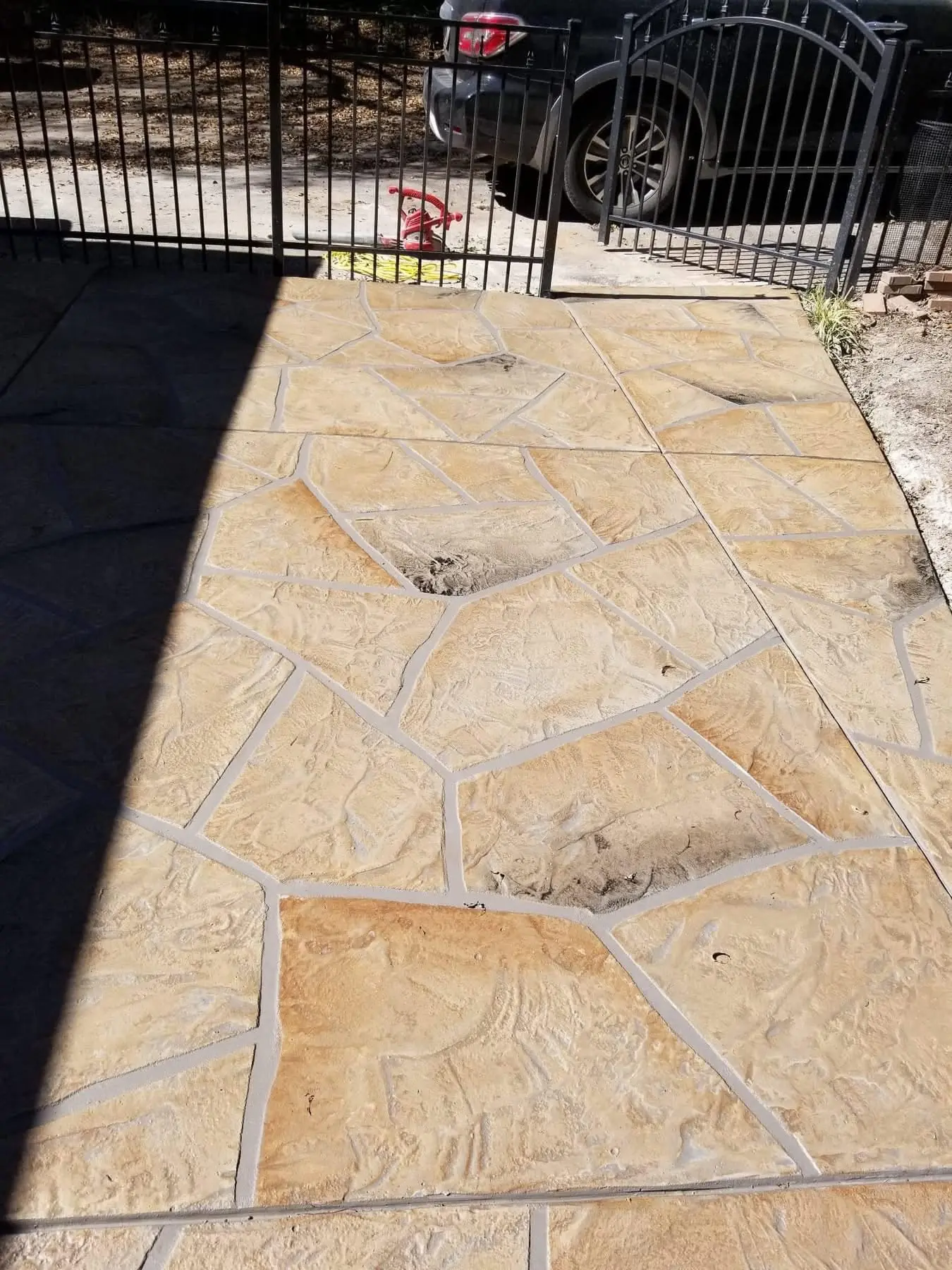 Tan hand-carved flagstone driveway apron with gray grout lines