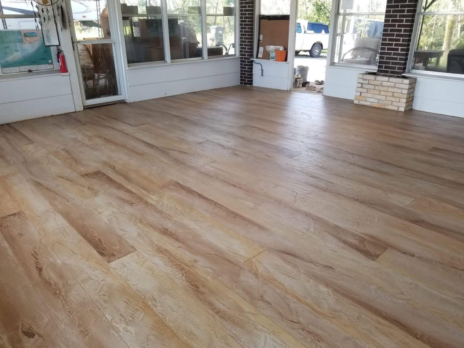 Wood-plank textured concrete overlay floor in a sunroom